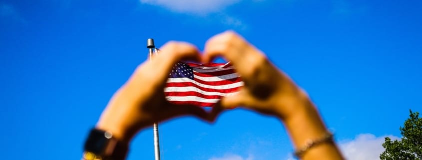 Hands making a heart over the US flag