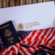 A passport and american flag on top of a table.